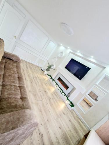 a living room with a couch and a flat screen tv at Dream ApartHotel in Turda