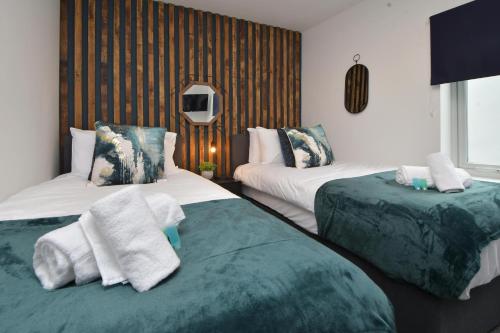 a bedroom with two beds with towels on them at Stay at Shobnall Road Rooms and Studios Burton in Burton upon Trent
