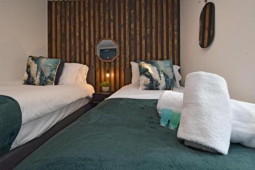a bedroom with two beds and a tv on the wall at Stay at Shobnall Road Rooms and Studios Burton in Burton upon Trent