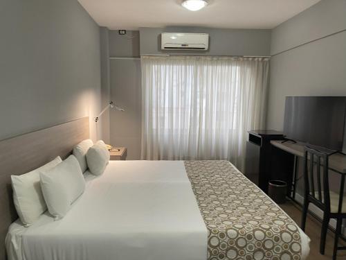 a hotel room with a bed and a television at Hotel 8 de Octubre in Buenos Aires