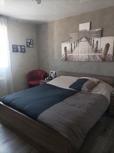une chambre avec un lit et une chaise rouge dans l'établissement maison proche du circuit du mans, à Spay