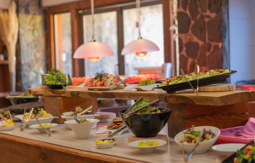 a buffet with many plates of food on a table at San Francisco Lodge in Los Andes
