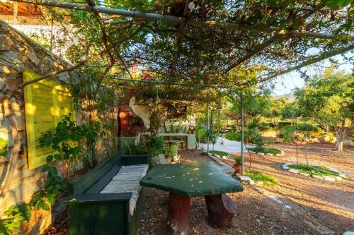 a garden with a green bench in front of a building at Garden house & sea view - Yu Yi in Chavania