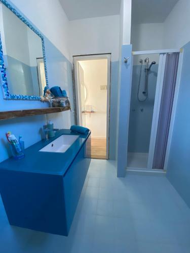 a blue bathroom with a sink and a shower at Il Mamuthones in Badesi
