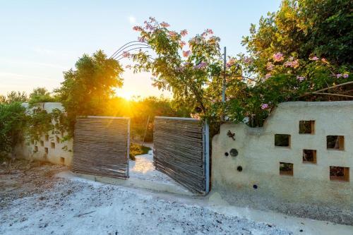 two gates in a fence with the sunset in the background at Garden house & sea view - Yu Yi in Chavania