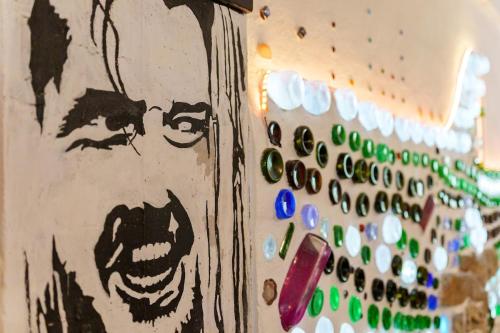 a wall with a painting of a face and a bunch of buttons at Garden house & sea view - Yu Yi in Chavania