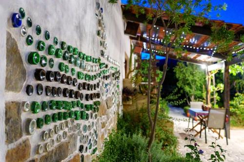 a wall with wine bottles on the side of a house at Garden house & sea view - Yu Yi in Chavania