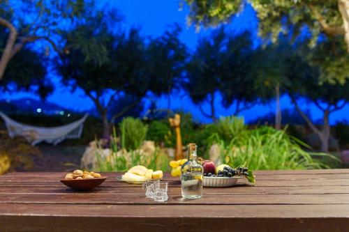 a table with a bottle and bowls of fruits and vegetables at Garden house & sea view - Yu Yi in Chavania