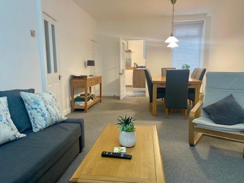 ein Wohnzimmer mit Sofa und Tisch in der Unterkunft Cape Cottage in Glyncorrwg