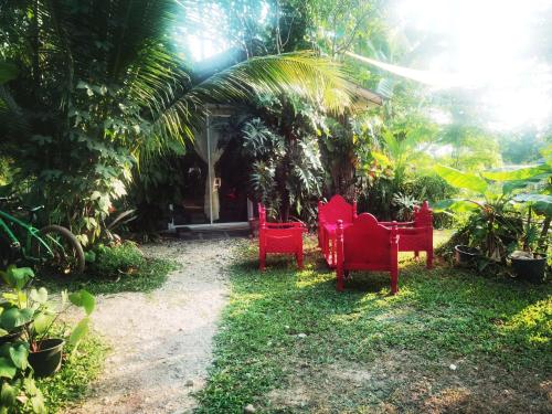 a group of red chairs in front of a house at ไทไอดิน in Ban Khui Khwang