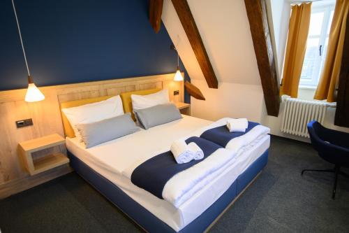 a bedroom with a large bed with two pillows at Hotel Gelber Löwe Großhabersdorf in Großhabersdorf