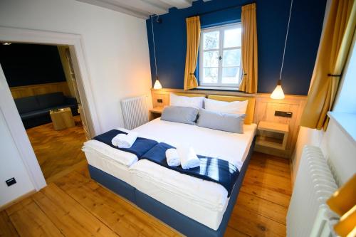 a bedroom with a large bed with blue walls at Hotel Gelber Löwe Großhabersdorf in Großhabersdorf