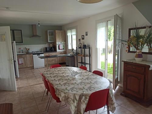 une cuisine avec une table et des chaises rouges dans une pièce dans l'établissement La voile du Trieux, à Saint-Clet