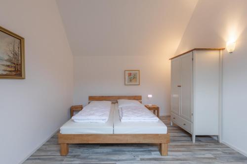 ein Schlafzimmer mit einem Bett und einem Schrank in der Unterkunft Fischerhaus 316 in Rechlin