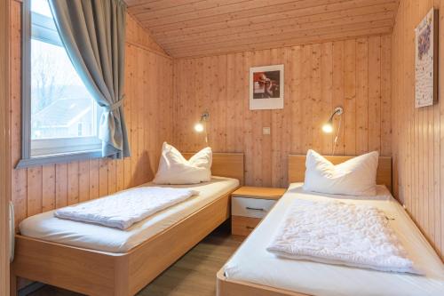 a bedroom with two beds and a window at Seeschwalbe 23 in Rechlin