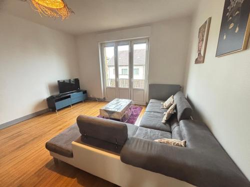 un salon avec un canapé et une télévision dans l'établissement Huitième Avenue Grand Parking Un Séjour à Part, à Metz