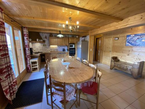 une cuisine avec une grande table et des chaises en bois dans l'établissement Chalet le Cerf : dans le centre de Châtel, à Châtel