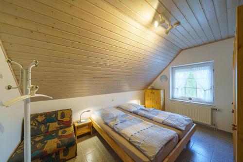 ein Bett in einem Zimmer mit Holzdecke in der Unterkunft Am Priel 20 DG in Otterndorf