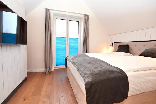 a bedroom with a large bed and two windows at Möwenweg Die Möwe im Möwenweg App 1 in Hohwacht