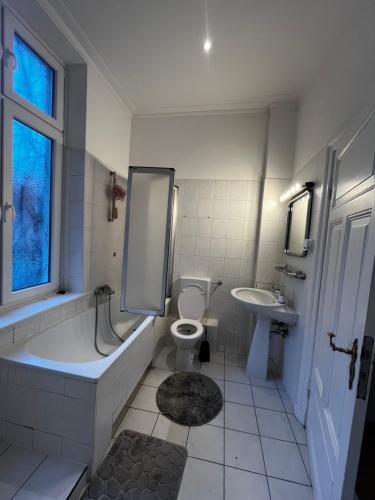 a bathroom with a tub and a toilet and a sink at Idyllische Altbauwohnung mit vielen Schlafmöglichkeiten in Rendsburg