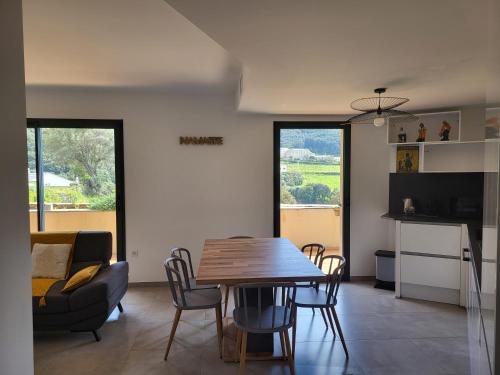 une cuisine et une salle à manger avec une table et des chaises dans l'établissement Vue Mer & Montagne, à Morsiglia