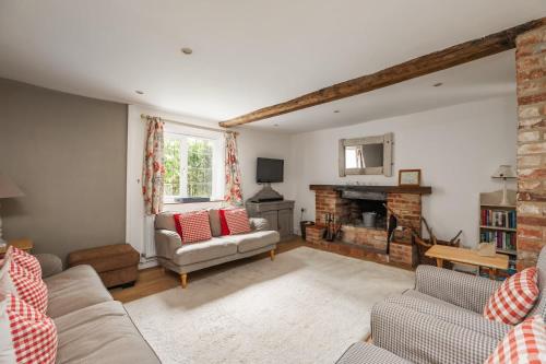 a living room with a couch and a fireplace at 18th Century Cottage in Dorset Countryside in Horton
