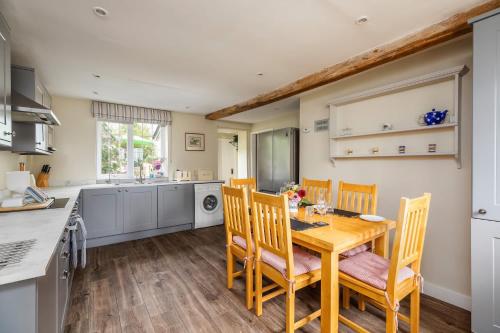 a kitchen and dining room with a wooden table and chairs at 18th Century Cottage in Dorset Countryside in Horton
