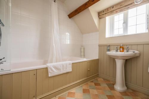 ein Badezimmer mit Waschbecken und Badewanne in der Unterkunft 18th Century Cottage in Dorset Countryside in Horton