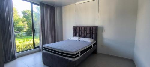 una camera da letto con un letto e una grande finestra di Casa campestre en Melgar a Melgar