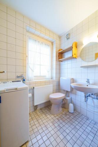 a bathroom with a toilet and a sink at Achtern Diek 28A in Otterndorf