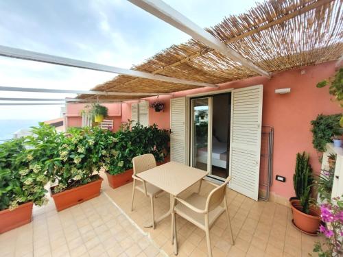 a patio with a table and chairs and plants at Casa sulla Punta in Marina di Camerota