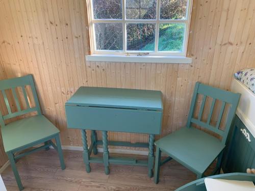 a piano and two chairs in a room with a window at Silverspring Glamping The Shepherds Hut in Constantine
