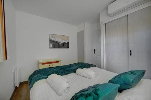 - une chambre avec 2 lits jumeaux et des oreillers verts et blancs dans l'établissement Vlaminck YourHostHelper, à Cannes
