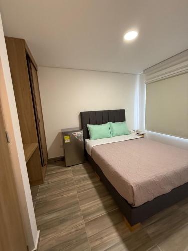 a bedroom with a bed with a blue pillow on it at Moravia Coliving in Bogotá