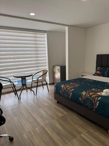 a bedroom with a bed and a table and chairs at Moravia Coliving in Bogotá