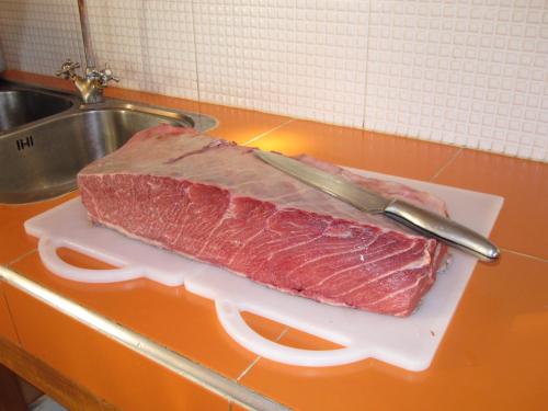 a piece of meat on a cutting board with a knife at Villa Zahra in Larache