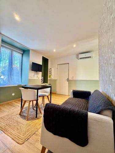 un salon avec un canapé et une table dans l'établissement Limoges Sud-LesCinqSuites-L'Eden - DABNB, à Limoges