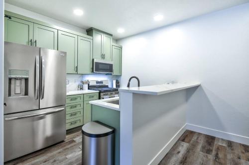 a kitchen with green cabinets and a stainless steel refrigerator at Luxury view, convenient place 304 in Juneau
