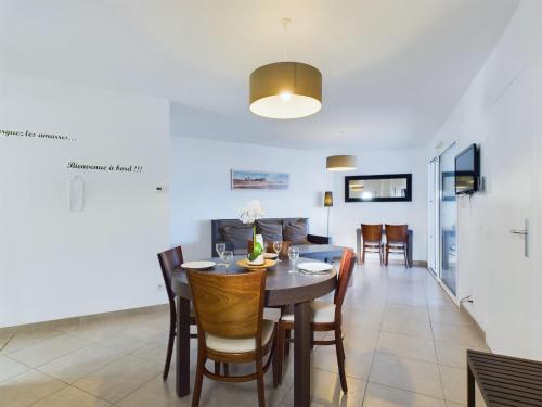 une salle à manger et un salon avec une table et des chaises dans l'établissement À 50m de la plage, appartement pour 6, vue mer, à La Tranche-sur-Mer
