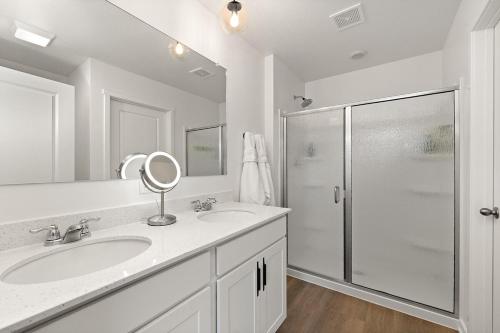 a white bathroom with a sink and a shower at House Divided in Ankeny