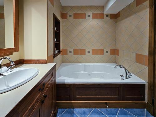 Un baño con una bañera grande y un lavabo. en Luxury Mountain Escape- Equinoxe 140-1, en Mont-Tremblant