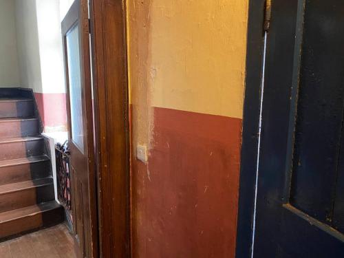 a room with a door and a stair case at Norfolk Chapel hideaway in Briston