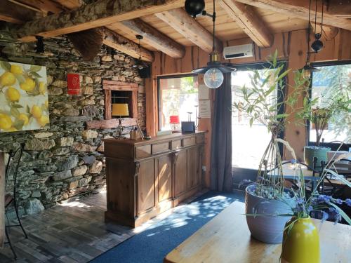 a kitchen with a table and a stone wall at L' Auberge du château in Génos