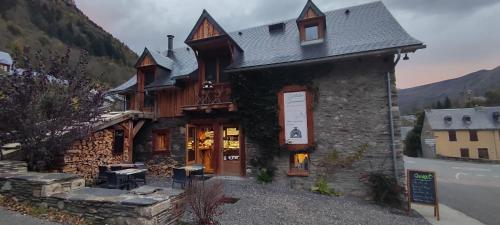 a building with a restaurant in front of a mountain at L' Auberge du château in Génos