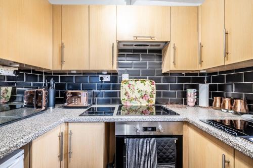 a kitchen with wooden cabinets and a stove top oven at Charming character lodge in cemetery grounds in Exeter