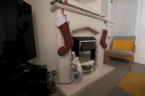 a living room with christmas stockings hanging from a fireplace at Charming character lodge in cemetery grounds in Exeter