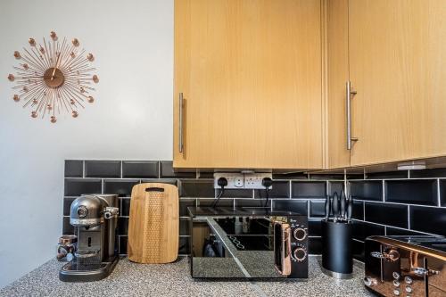 a kitchen counter with a coffee maker on the counter at Charming character lodge in cemetery grounds in Exeter