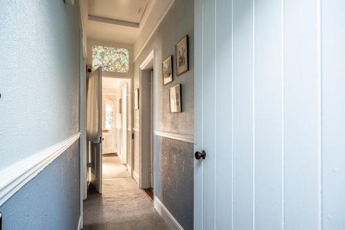 a hallway with a blue wall and a door at Charming character lodge in cemetery grounds in Exeter