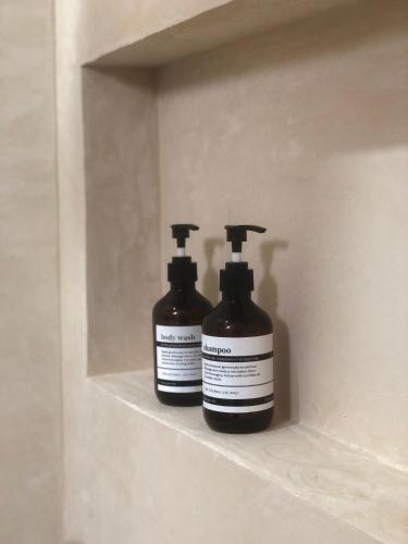 two bottles of soap are sitting on a shelf at Stylish room in Punta Allen town in Punta Allen