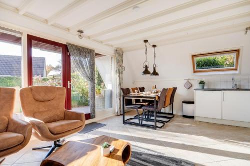 a kitchen and living room with a table and chairs at Gaai I Prachtige Vakantiewoning nabij Bos in Zwiggelte